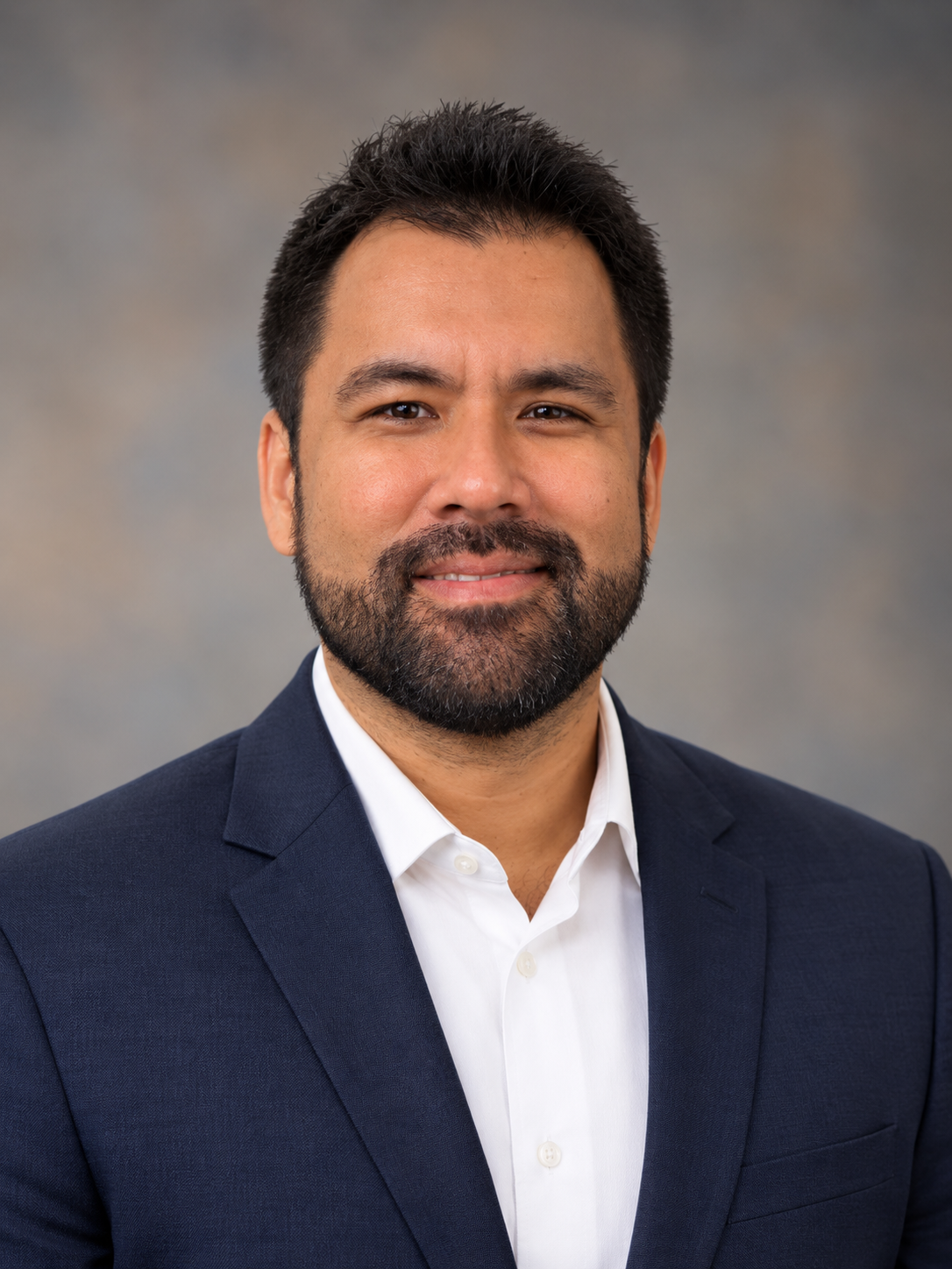 MaxMcGahanHeadshot - Geo-Technology Associates, Inc. Professional headshot of a man with dark hair and beard wearing a navy blazer and white shirt smiling
